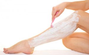 Женщина бреет ноги