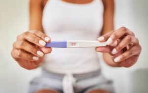 Женщина держит в руках тест на беременность