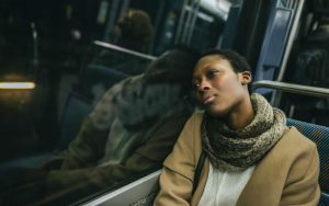 Задумчивая темнокожая женщина в автобусе