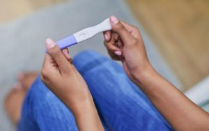 Женщина изучает тест на беременность
