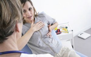 Женщина жалуется врачу на чувствительную грудь