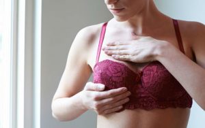 Женщина проверяет грудь на рак