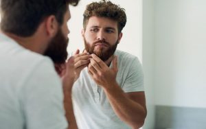 Мужчина изучает свою бороду