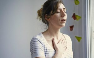 Женщина страдает болью в грудной клетке