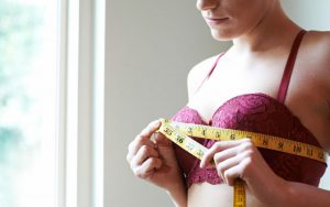 Женщина оценивает размер груди